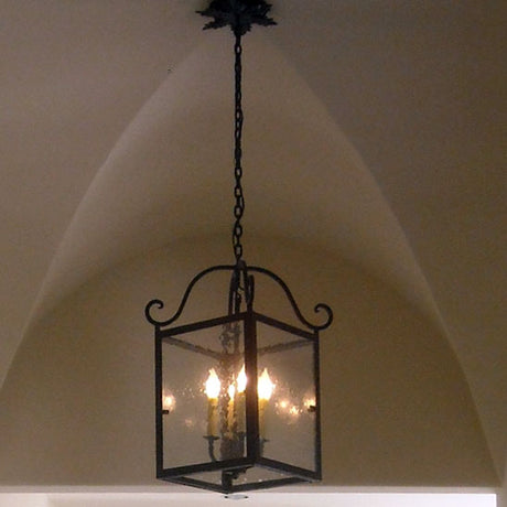 A decorative wrought iron pendant with a square frame and curved accents, featuring multiple candle-like lights. Ideal for adding elegance to any room.