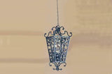 A beautifully crafted pendant light featuring intricate wrought iron detailing, showcasing elegant curves and flourishes, ideal for enhancing any space.