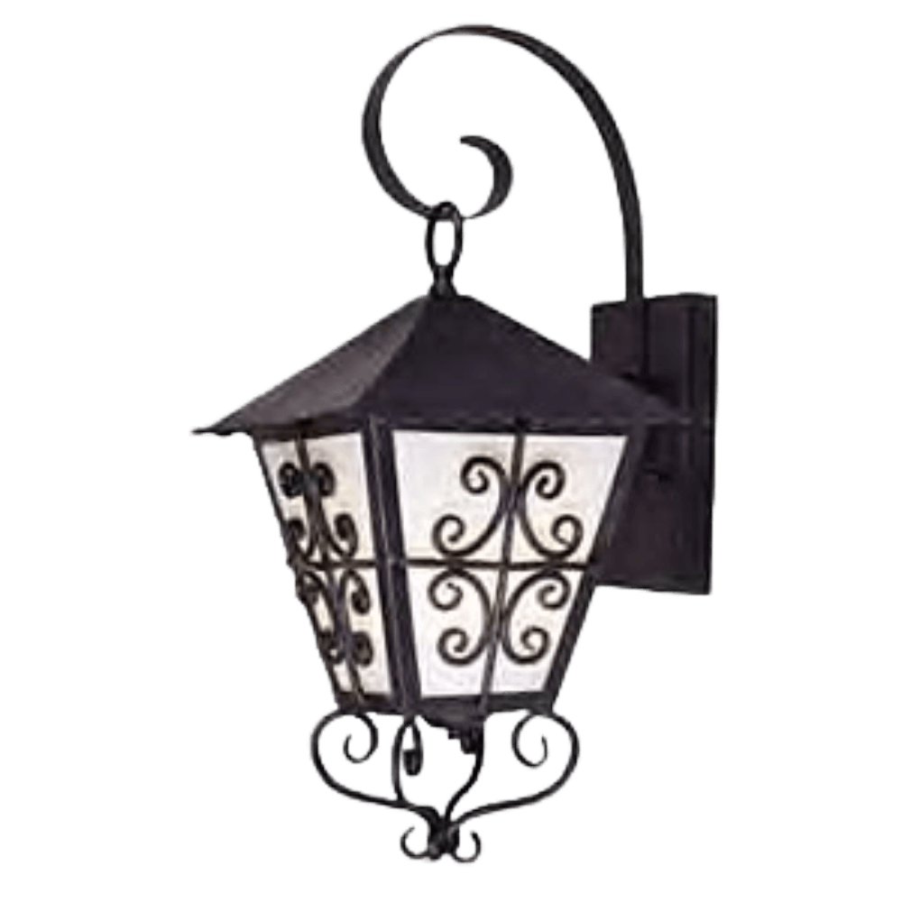 A decorative wall sconce featuring a hexagonal design with a pointed roof. The fixture showcases intricate scrollwork in black wrought iron and frosted glass panels, creating a warm, inviting glow for exterior or interior spaces.