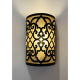 A beautifully crafted wall sconce featuring intricate black wrought iron detailing with a warm, glowing inner light. The design showcases an ornate pattern that adds elegance and charm to any space, making it a standout lighting piece. Perfect for enhancing the ambiance in both traditional and contemporary settings.