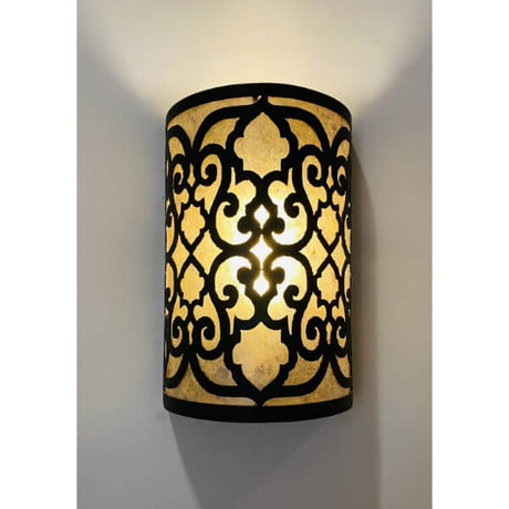 A beautifully crafted wall sconce featuring intricate black wrought iron detailing with a warm, glowing inner light. The design showcases an ornate pattern that adds elegance and charm to any space, making it a standout lighting piece. Perfect for enhancing the ambiance in both traditional and contemporary settings.