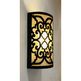 A decorative wrought iron sconce featuring intricate swirling patterns and a warm glow from within, enhancing any space with its artistic design.