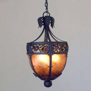 A beautifully crafted pendant featuring intricate wrought iron design and decorative leaf accents, illuminated from within by a warm, glowing light.