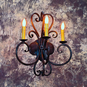 A beautifully designed wrought iron chandelier featuring graceful curves and three candle-like lights. The fixture combines intricate scrollwork and a rustic finish, enhancing the ambiance of any space.