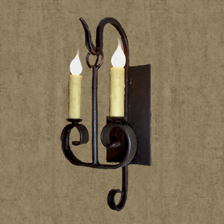 A black wrought iron wall sconce featuring two candle-like lights, elegantly accented with scrollwork for a classic and inviting ambiance.