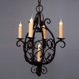 A beautifully crafted wrought iron chandelier featuring elegant curves and scrollwork. It holds five candle-like bulbs, casting a warm and inviting glow. Ideal for adding a touch of classic charm to any space.